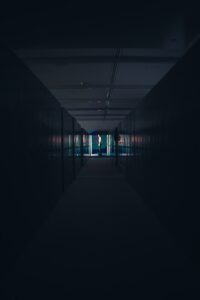 a dark hallway with a person standing in the doorway