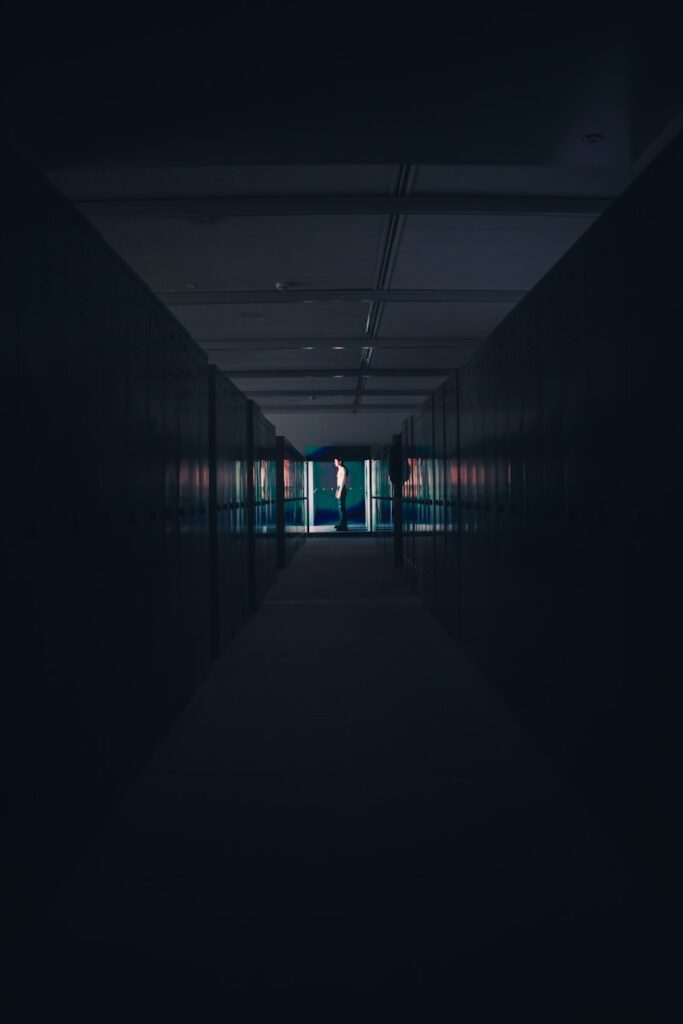 a dark hallway with a person standing in the doorway